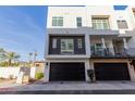 Contemporary three-story home with a black garage door and landscaped front yard at 1717 E Morten Ave # 7, Phoenix, AZ 85020