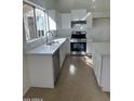 Bright and open kitchen with white cabinets, quartz countertops and a stainless steel range at 21443 N 29Th Dr, Phoenix, AZ 85027