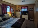 Cozy bedroom features wood paneling, large window, and dresser with mirror at 44 S Hawes Rd # B7, Mesa, AZ 85208