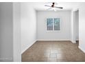 Inviting bedroom featuring tile floors, a ceiling fan, and large shuttered window at 5446 S Sandstone Ct, Gilbert, AZ 85298