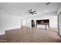 Spacious living room with tile flooring, ceiling fan, and open concept to the kitchen at 5446 S Sandstone Ct, Gilbert, AZ 85298