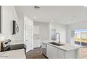 Modern kitchen with white cabinets, stainless steel appliances, and a center island with a sink at 5742 E Smeaton Pl, San Tan Valley, AZ 85140