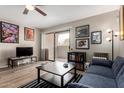 Living room with ceiling fan, sliding glass door to balcony, and eclectic decorations at 715 S Extension Rd # 70, Mesa, AZ 85210