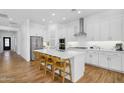 Modern kitchen with white cabinets, stainless steel appliances, and a large island with seating at 8140 E June St, Mesa, AZ 85207