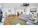 Open-concept living room featuring wood floors, neutral decor, and seamless access to the kitchen at 8140 E June St, Mesa, AZ 85207