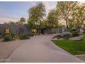 Beautifully landscaped home featuring desert foliage, mature trees, and an inviting driveway at 8433 E Cholla St, Scottsdale, AZ 85260