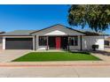 Charming single-story home featuring a well-manicured front yard and a striking red front door at 8602 W Clarendon Ave, Phoenix, AZ 85037