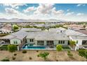 Beautiful aerial shot showcases a home with pool, landscaped yard, and mountain views at 11203 N Northfield St, Surprise, AZ 85388