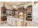 Spacious kitchen featuring a large island, custom cabinetry, granite countertops, and modern appliances at 11225 E Starflower Ct, Chandler, AZ 85249
