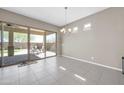Bright dining space with sliding doors, tiled floor, and views of the brick-paved backyard at 18837 N Cook Dr, Maricopa, AZ 85138