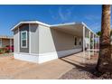 Charming home featuring a covered porch and gray siding, surrounded by desert landscaping at 2650 W Union Hills Dr # 91, Phoenix, AZ 85027
