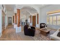 Open-concept living room featuring wood floors, beamed columns, and abundant natural light at 27171 N 73Rd St, Scottsdale, AZ 85266