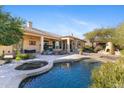 An inviting backyard pool with an attached jacuzzi, stucco columns, and a covered patio for comfortable outdoor living at 41601 N River Bend Rd, Anthem, AZ 85086