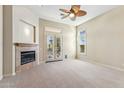 An expansive bedroom features a cozy fireplace, neutral tones, plush carpeting, and a ceiling fan for added comfort at 41601 N River Bend Rd, Anthem, AZ 85086