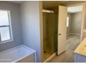 Bright bathroom features a bathtub with shower head and sliding glass shower doors at 420 S 98Th Way, Mesa, AZ 85208