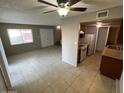 Open-concept living room with tile flooring connecting to the kitchen with stainless steel appliances at 4258 N 68Th Ln, Phoenix, AZ 85033