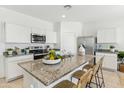 Stylish kitchen featuring granite countertops, modern appliances, white cabinetry, and an island with barstool seating at 631 W Freedom St, Florence, AZ 85132