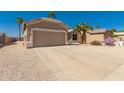 Well-maintained one-story house showcasing a desert landscape, a wide driveway, and a two-car garage at 6460 S Springs Pl, Chandler, AZ 85249