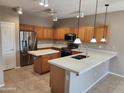 Spacious kitchen featuring a center island, stainless steel appliances, and ample wood cabinetry at 6460 S Springs Pl, Chandler, AZ 85249