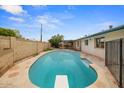 Sparkling swimming pool featuring a diving board surrounded by a stone patio and block fencing at 6707 N 42Nd Ave, Phoenix, AZ 85019