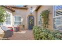 Inviting front entrance showcasing an iron door, arched doorway and small courtyard with chairs at 8965 E Mountain Spring Rd, Scottsdale, AZ 85255