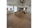 Bright living room with a large ceiling fan and an island with a built-in wine rack at 15659 W Ripple Cir, Goodyear, AZ 85338