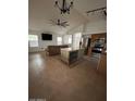 Bright living room with a large ceiling fan and an island with a built-in wine rack at 15659 W Ripple Cir, Goodyear, AZ 85338