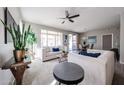 Bright and airy living room featuring neutral tones, a ceiling fan, and ample natural light at 16137 W Quail Creek Ln, Surprise, AZ 85374