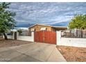 The front yard has a red metal gate and a white brick fence surrounding the property at 17841 N 20Th St, Phoenix, AZ 85022