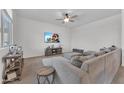 Comfortable living room with plush sectional sofa, ceiling fan, and a wall-mounted TV at 23290 N 175Th Ln, Surprise, AZ 85387