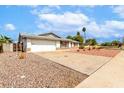 Single-story home with desert landscaping, paved driveway, two car garage, and partial fencing in a low traffic area at 2540 E Riviera Dr, Tempe, AZ 85282