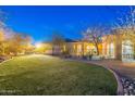 Expansive backyard with a large grassy area, mature trees, and a wrought-iron fence at 32742 N 15Th Gln, Phoenix, AZ 85085