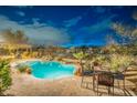 Inviting backyard pool area with a waterfall feature and covered patio with string lights at 32742 N 15Th Gln, Phoenix, AZ 85085