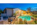 Backyard pool area featuring a covered patio, outdoor dining furniture, and desert landscaping at 32742 N 15Th Gln, Phoenix, AZ 85085