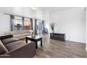 Bright living room with wood floors, neutral walls, and comfortable sofas by window with natural light at 3500 N Hayden Rd # 2201, Scottsdale, AZ 85251