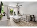 Cozy living room features a comfortable sofa, brick accent wall, and access to the outdoor patio at 4800 N 68Th St # 225, Scottsdale, AZ 85251