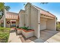 Close-up of front exterior with terra cotta roof, two-car garage, and gated front patio at 5139 N 76Th Pl, Scottsdale, AZ 85250