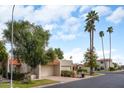 Street view featuring terra cotta rooflines, lush desert landscaping, and tall palm trees at 5139 N 76Th Pl, Scottsdale, AZ 85250