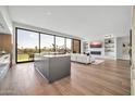 Open-concept living room with a fireplace, built-in shelves, and floor-to-ceiling windows showcasing golf course views at 6331 E Phoenician Blvd # 6, Scottsdale, AZ 85251