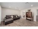 The spacious living room features wood-look tile flooring, recessed lighting and a leather couch at 7807 E Palm Ln, Scottsdale, AZ 85257