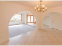 Open-concept living room featuring a large chandelier, beautiful tile flooring, and natural light at 10421 N 77Th Pl, Scottsdale, AZ 85258