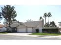 Angle view of a home with a large, well-maintained lawn, an attached three-car garage, and mature trees at 1119 E Southshore Dr, Gilbert, AZ 85234