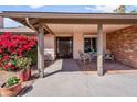 Covered front porch with seating area and beautiful bougainvillea at 11820 S Half Moon Dr, Phoenix, AZ 85044