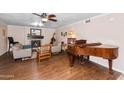 Cozy living room featuring a fireplace, piano, and hardwood floors at 11820 S Half Moon Dr, Phoenix, AZ 85044