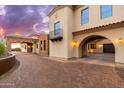 Exterior close-up featuring brick driveway and stone accents, including a wrought-iron balcony at 12980 E Cochise Rd, Scottsdale, AZ 85259