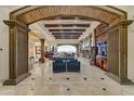 Open-concept living room with beamed ceilings, fireplace, stone columns, and scenic mountain views at 14371 E Kalil Dr, Scottsdale, AZ 85259