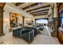 Spacious living room featuring a fireplace, beamed ceilings, an ornate cabinet and an adjacent music room at 14371 E Kalil Dr, Scottsdale, AZ 85259