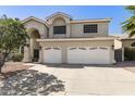 This two-story home boasts an expansive driveway and a two-car garage, complemented by mature trees and landscaping at 16008 S 13Th Way, Phoenix, AZ 85048