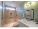 Well-lit bathroom with a walk-in shower featuring neutral tile, grab bars, and modern fixtures at 1668 E Valerie St, Casa Grande, AZ 85122