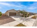 Single-story home with a well-manicured lawn, desert landscaping, and a two-car garage at 18621 W Hackamore Dr, Surprise, AZ 85387